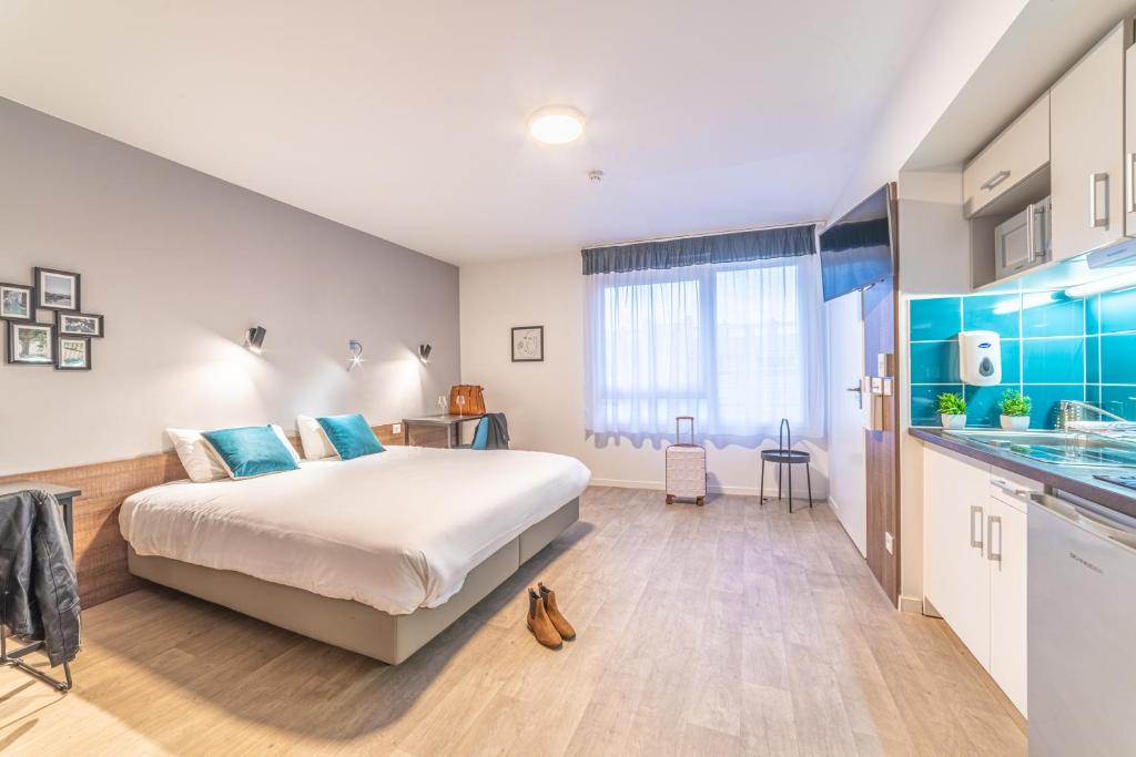 1 Schlafzimmer mit einem großen Bett und einer Küche in der Unterkunft Break & Home Paris Italie Porte de Choisy in Ivry-sur-Seine