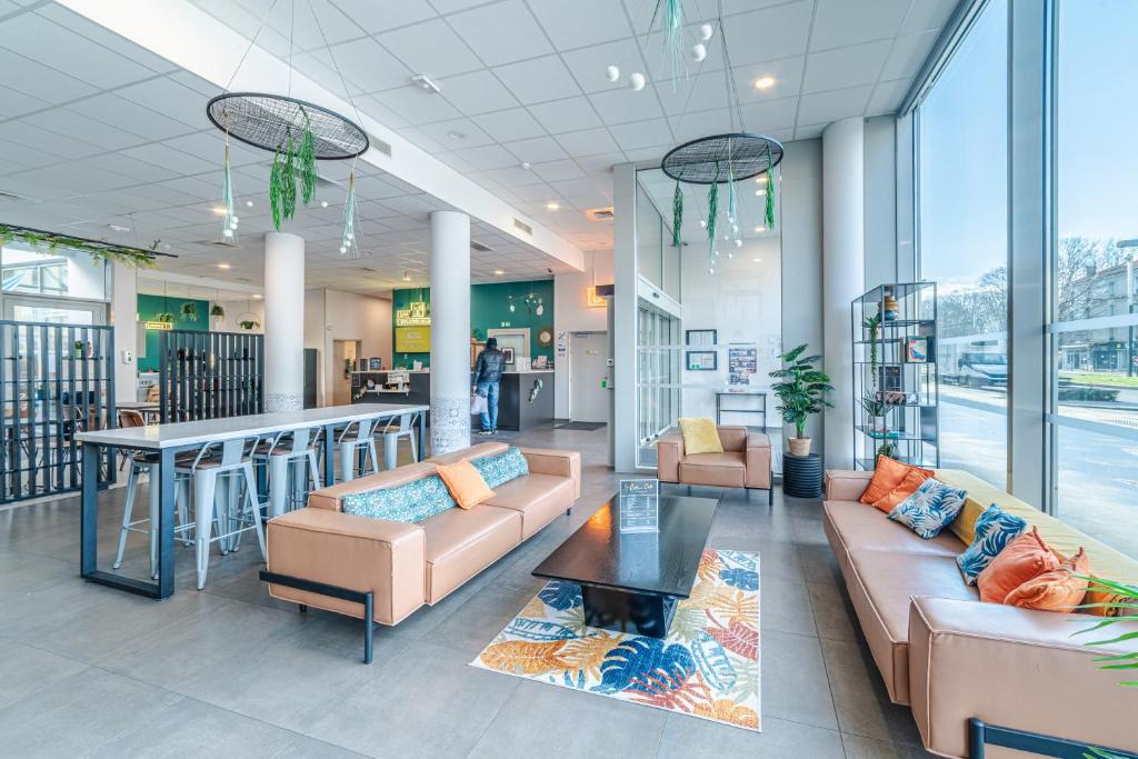 a lobby with couches and a bar in a store at Break & Home Paris Italie Porte de Choisy in Ivry-sur-Seine