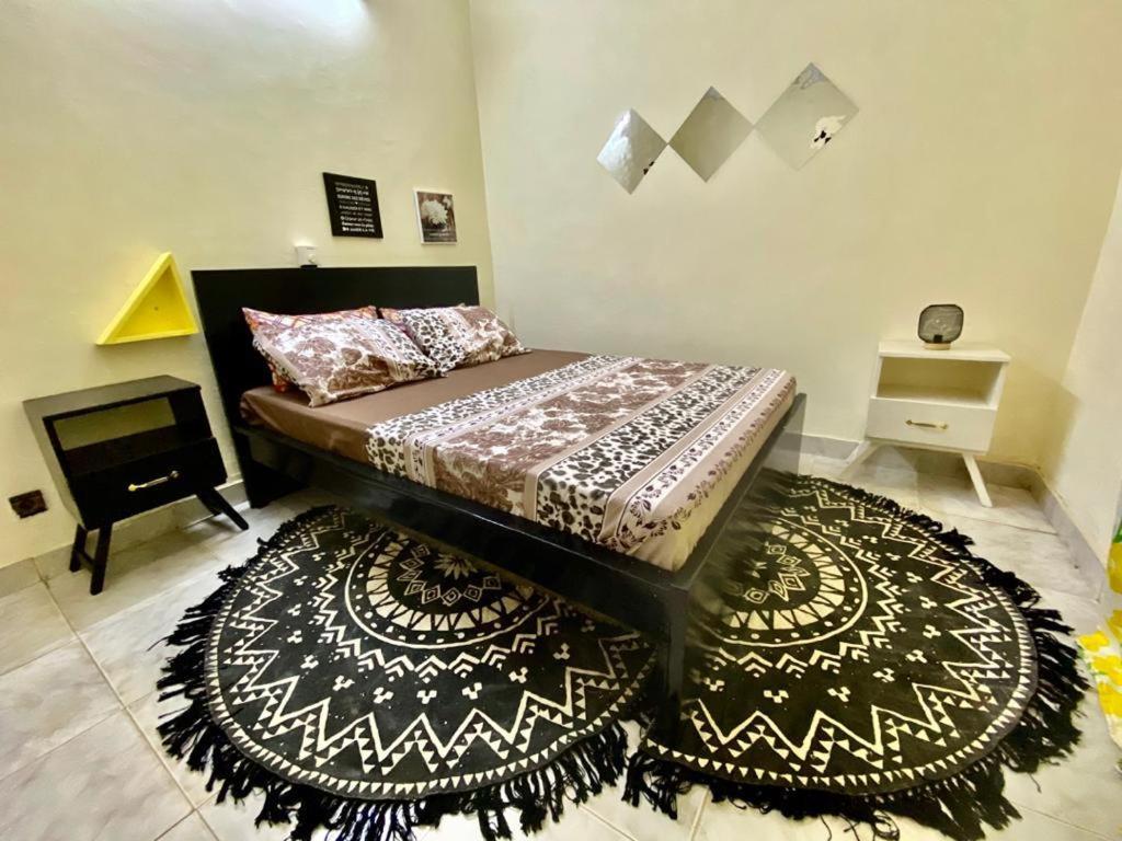 a bedroom with a bed with a rug and a table at Zombré in Ouagadougou