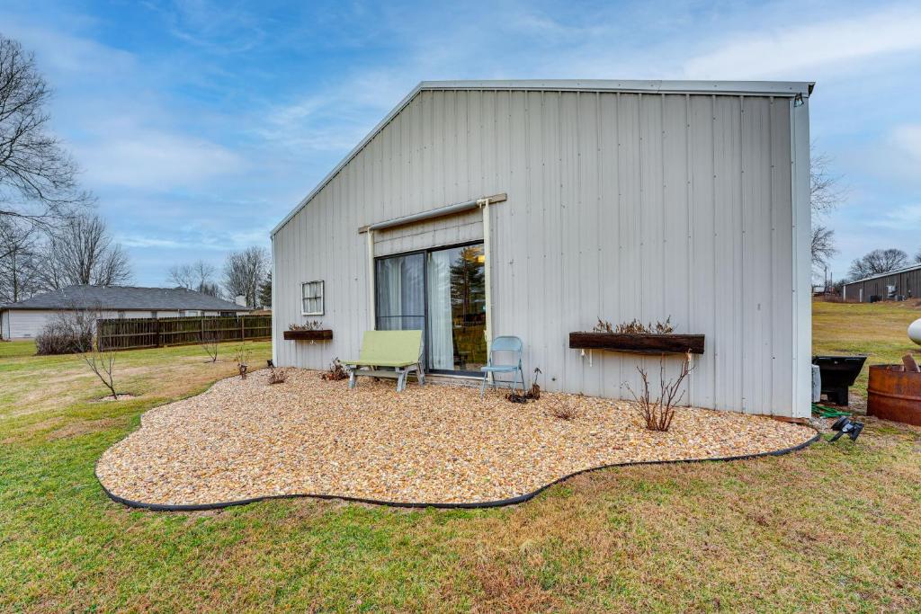 a white building with a bench and a chair at Missouri Couples Retreat Shouse with Patio, Yard in Nixa