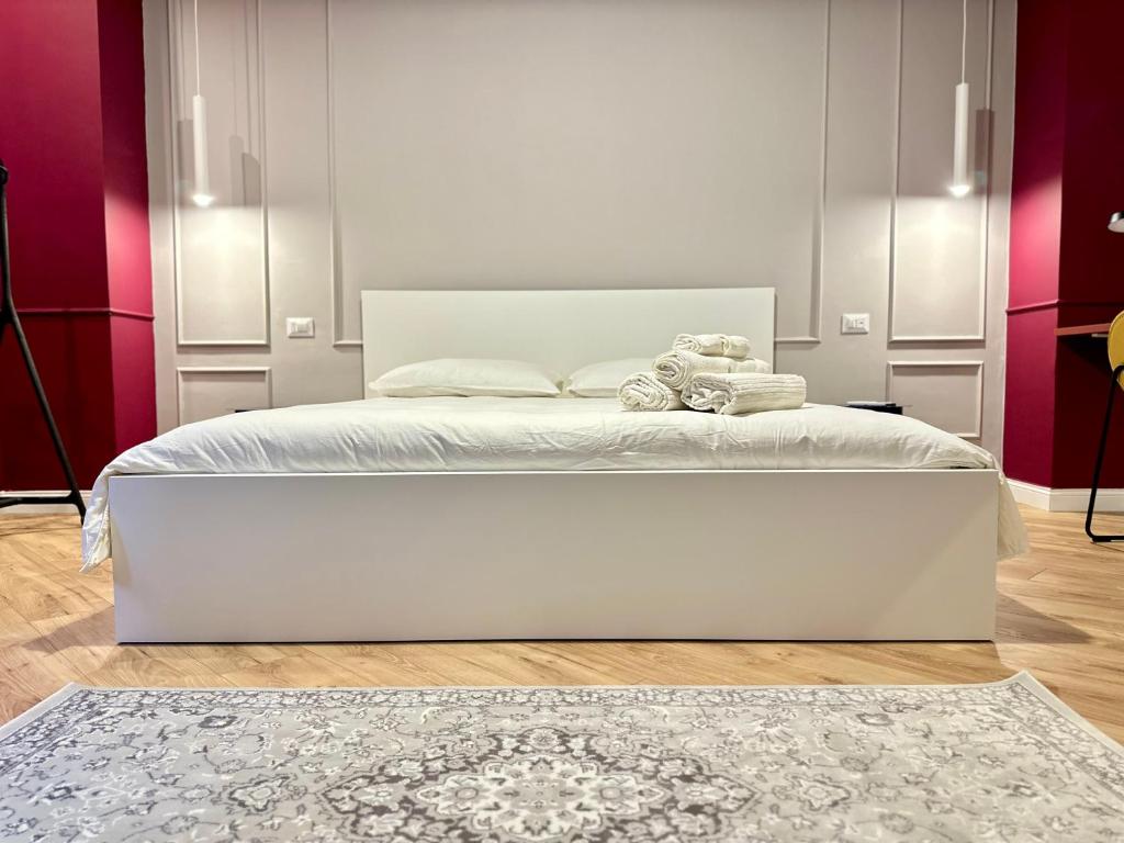 uma grande cama branca num quarto com paredes cor-de-rosa em Art’n’ shelter apartament em Bari