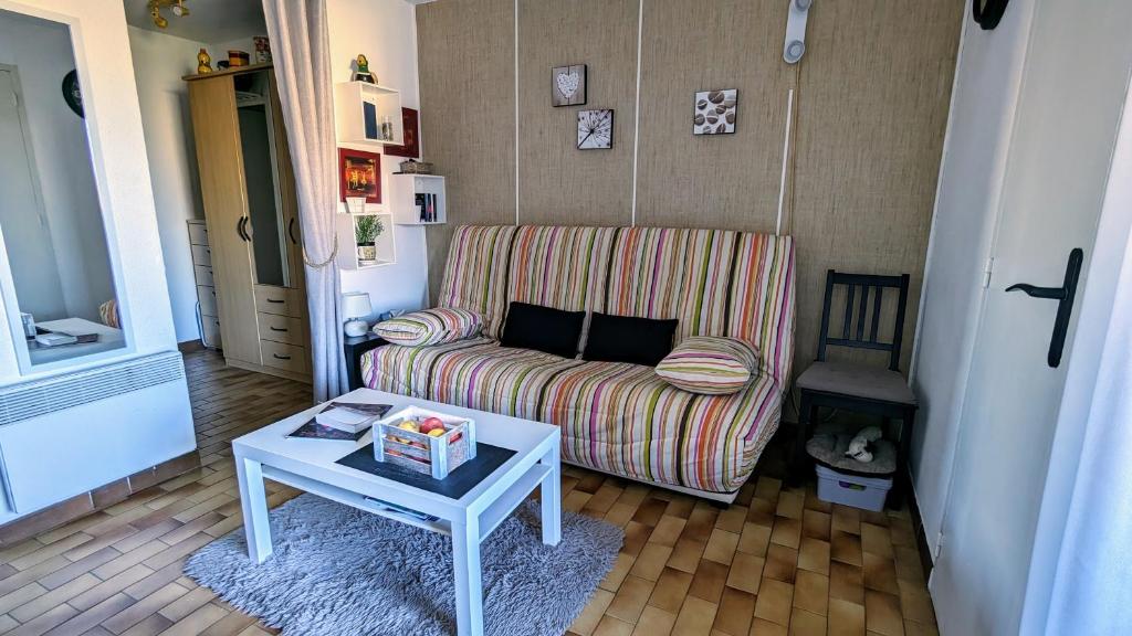 un salon avec un canapé et une table dans l'établissement 049 Beau studio cabine quartier falaises avec parking, au Cap d'Agde