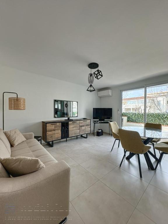 un salon avec un canapé et une table dans l'établissement AGENCIA appartement 2 Pièces lumineux terrasse, à Cannes