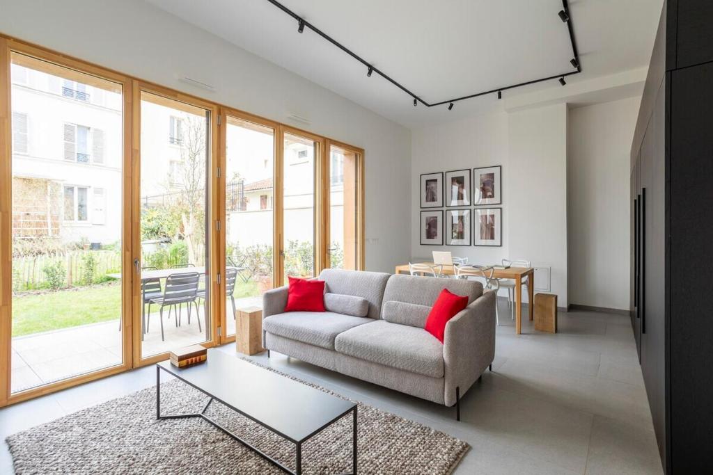 Modern Loft in Paris Montreuil في مونتروي: غرفة معيشة مع أريكة وطاولة