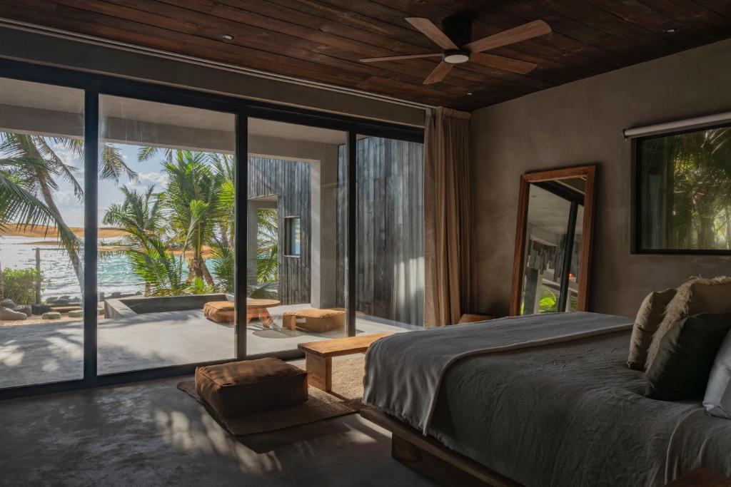 a bedroom with a bed and a view of a patio at Umi Tulum in Tulum