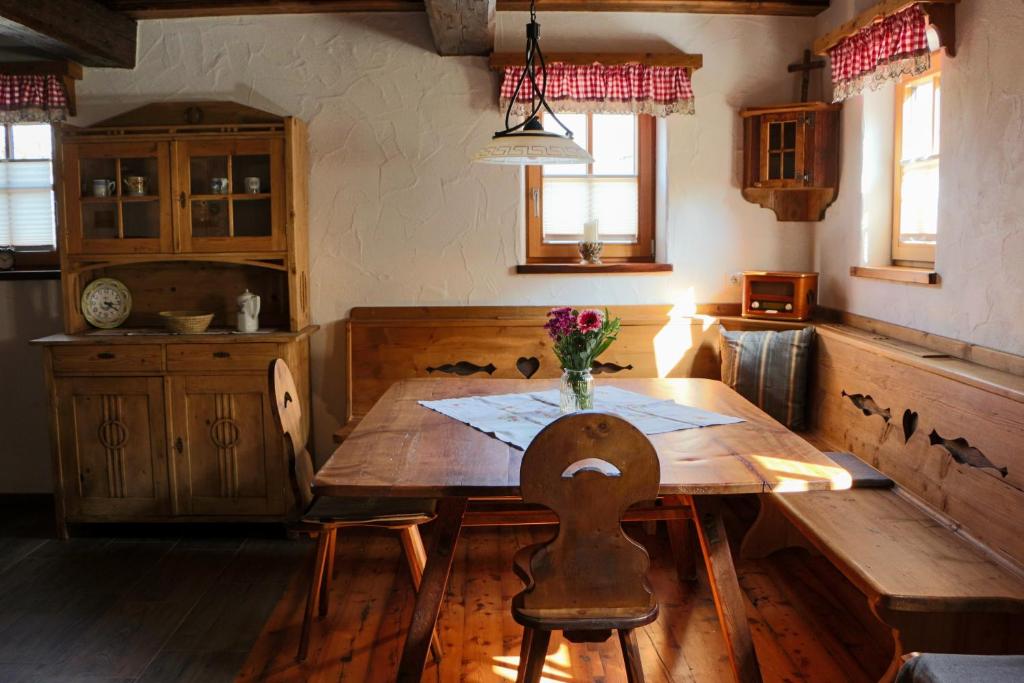 une cuisine avec une table en bois et un vase de fleurs. dans l'établissement Manggehof, à Grosshattenberg