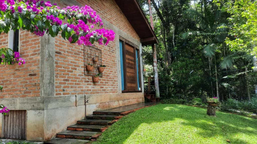 een huis met paarse bloemen erop bij Casa da Mata in Itapema