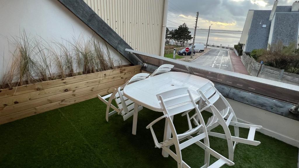 d'une table et de chaises blanches sur un balcon. dans l'établissement location front de mer Plein Soleil, au Crotoy
