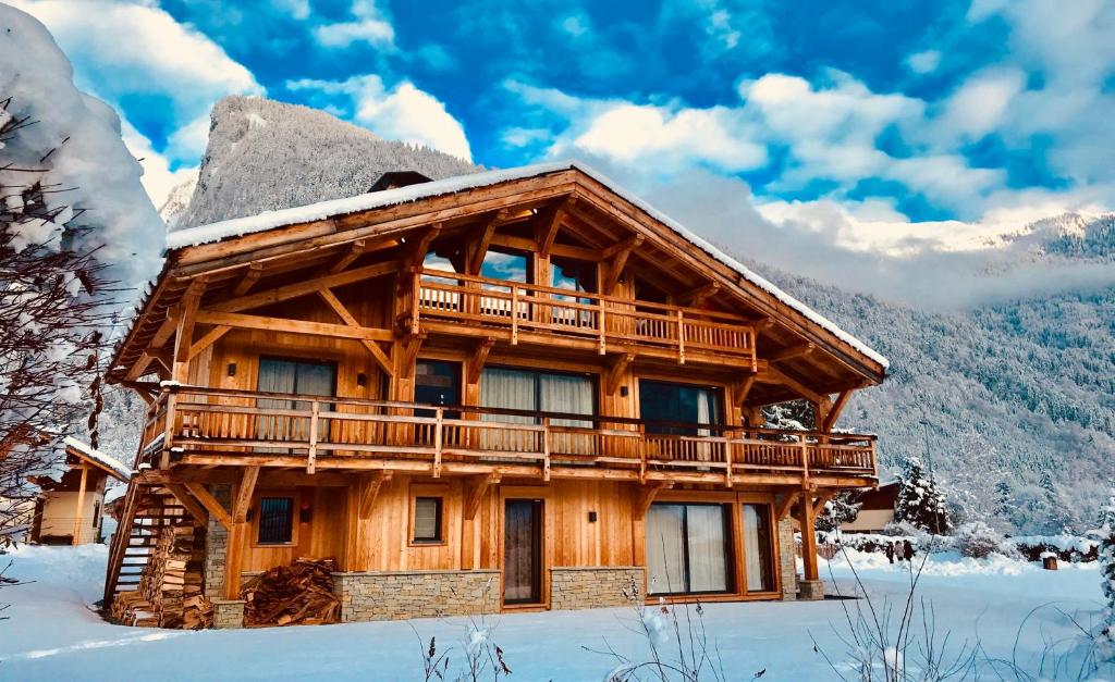 una cabaña de madera en la nieve cubierta de nieve en Chalet de 4 chambres a Samoens a 700 m des pistes avec jacuzzi jardin amenage et wifi, en Samoëns