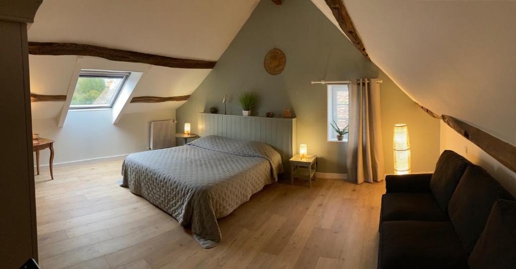 - une chambre avec un lit et un canapé dans l'établissement Le Béguinage, à Cour-Cheverny