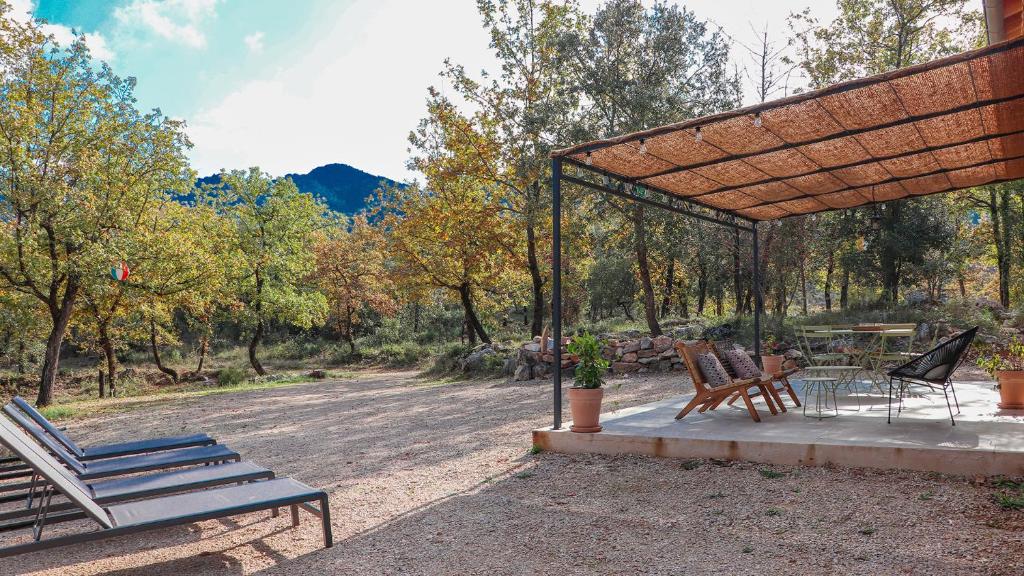 einen Pavillon mit Stühlen, einem Tisch und einem Picknicktisch in der Unterkunft Villa Cinsault, un bijou pour votre séjour en Provence Verte in La Celle