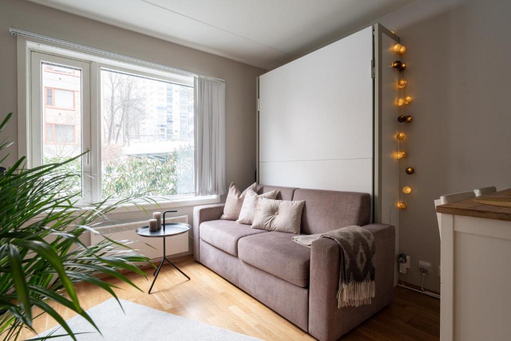 a living room with a couch and a large window at Beautiful home in the heart of Oslo (Grünerløkka) in Oslo