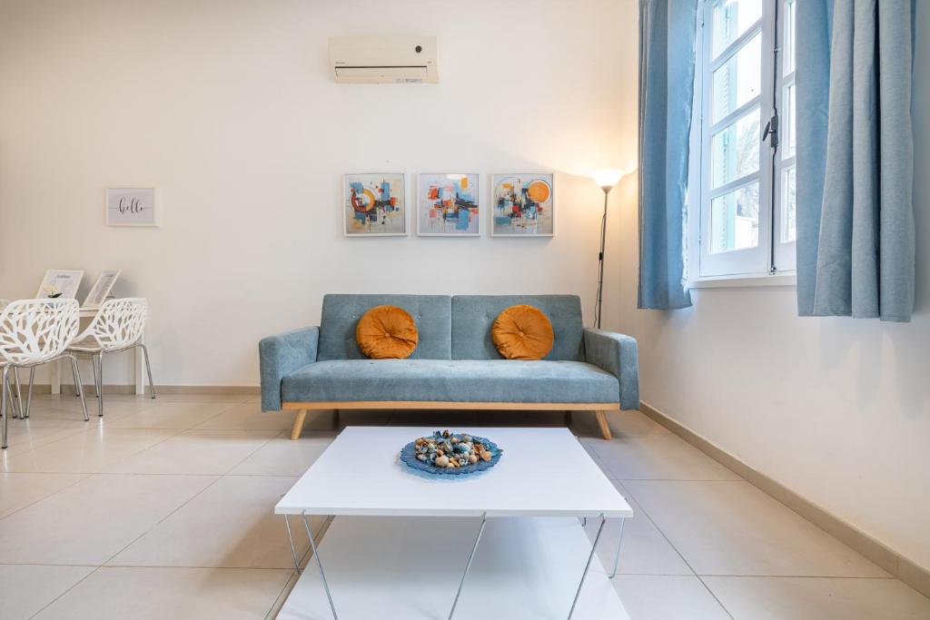 a living room with a blue couch and a table at Pageant Homes in Nicosia