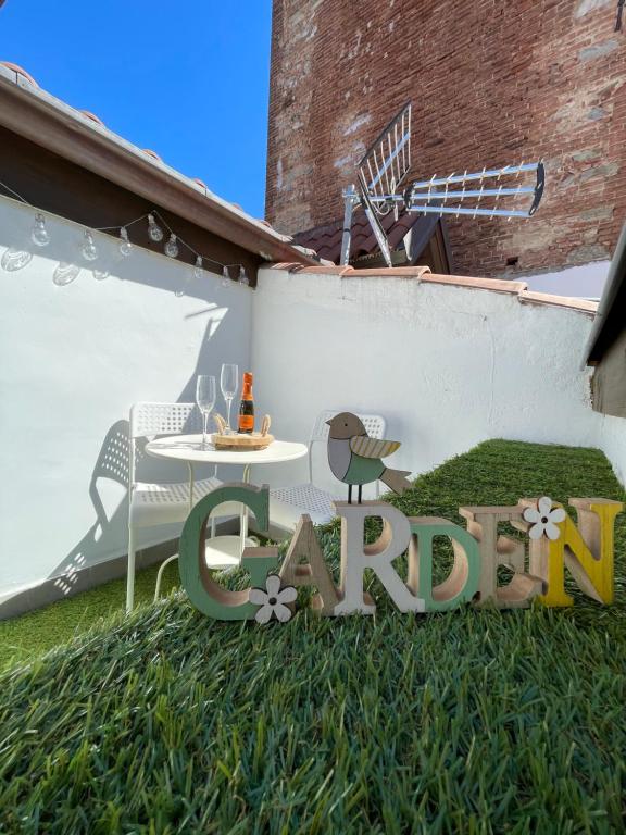 a sign in the grass with a table and a bird at Garden House Cit Turin in Turin