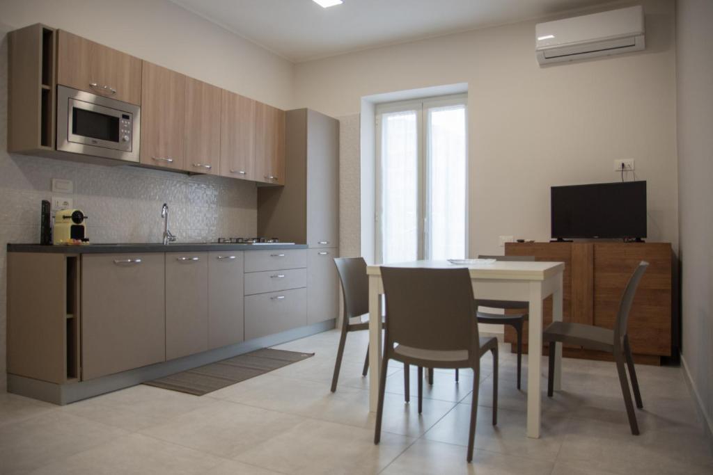 a kitchen with a table and chairs and a microwave at Maison Noel in Cava deʼ Tirreni