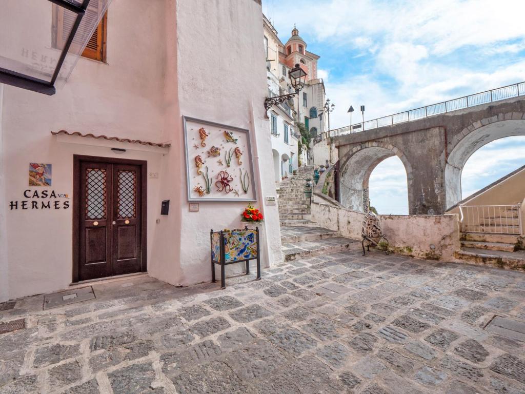 a building on a street with a bridge in the background at Casa Hermes in Atrani