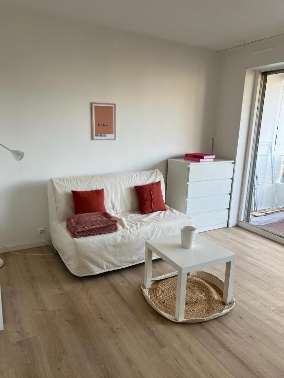 uma sala de estar com um sofá branco e uma mesa em Le Central - Studio avec terrasse Camas,Timone em Marselha