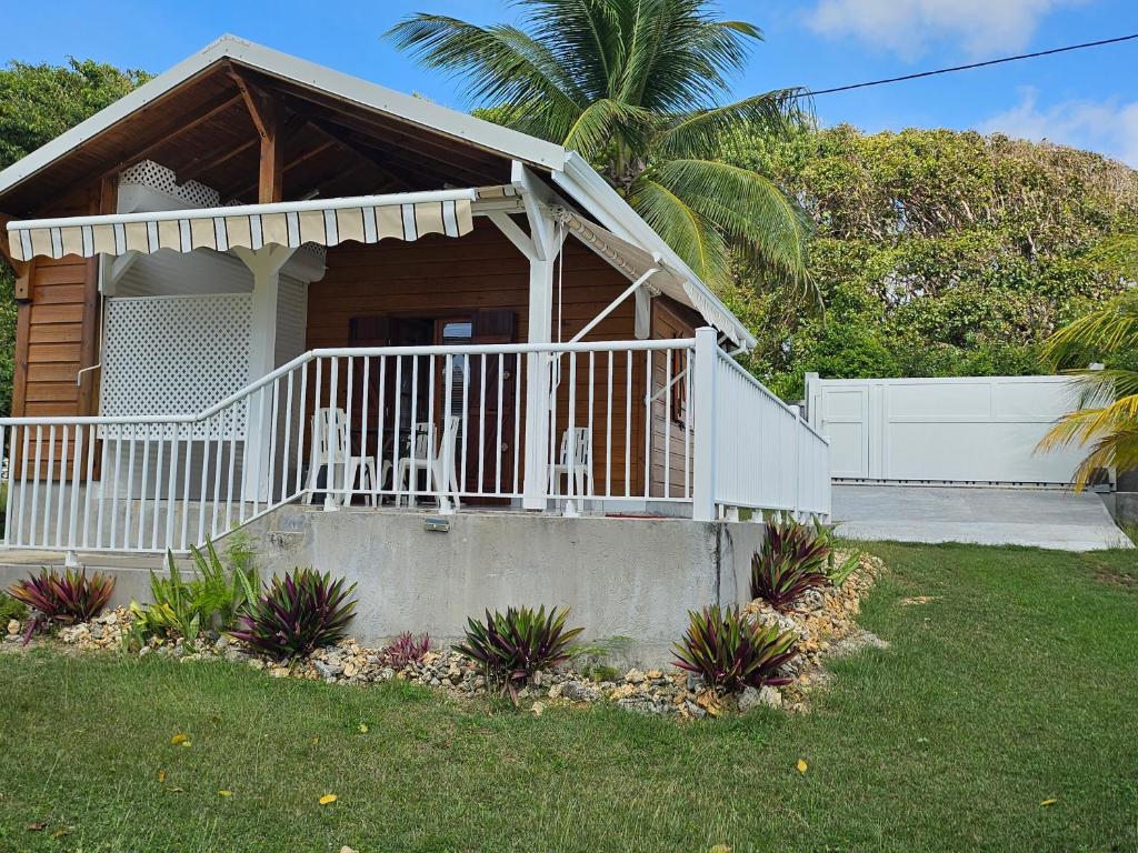 una casa con un portico con due sedie sopra di bungalow Bô Sicrié a Le Moule