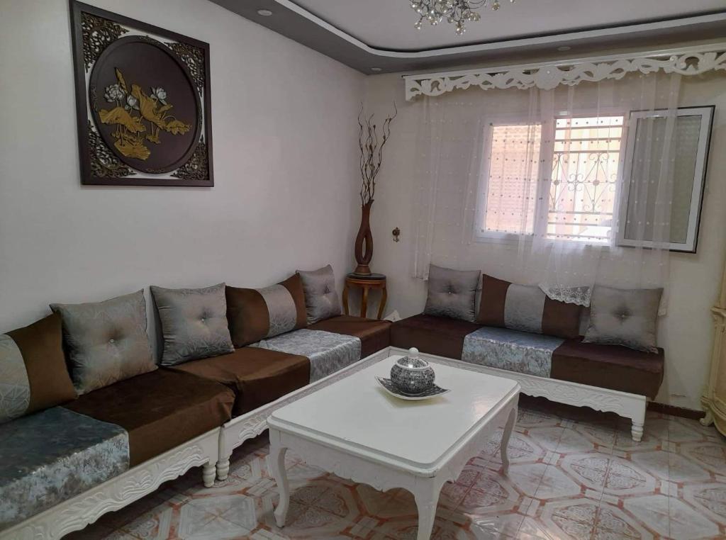 ein Wohnzimmer mit einem Sofa und einem Tisch in der Unterkunft Appartement à Oran in Oran