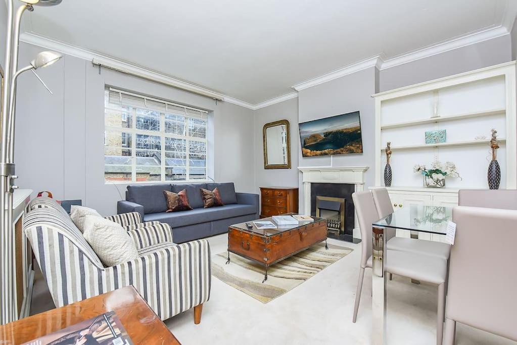 a living room with a blue couch and a fireplace at 2 Bedroom Apartment- Mayfair (4) in London