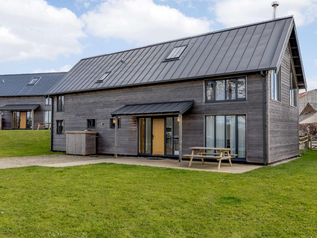 a house with a metal roof and a picnic table at 3 Bed in Ashreigney 65742 in Ashreigney