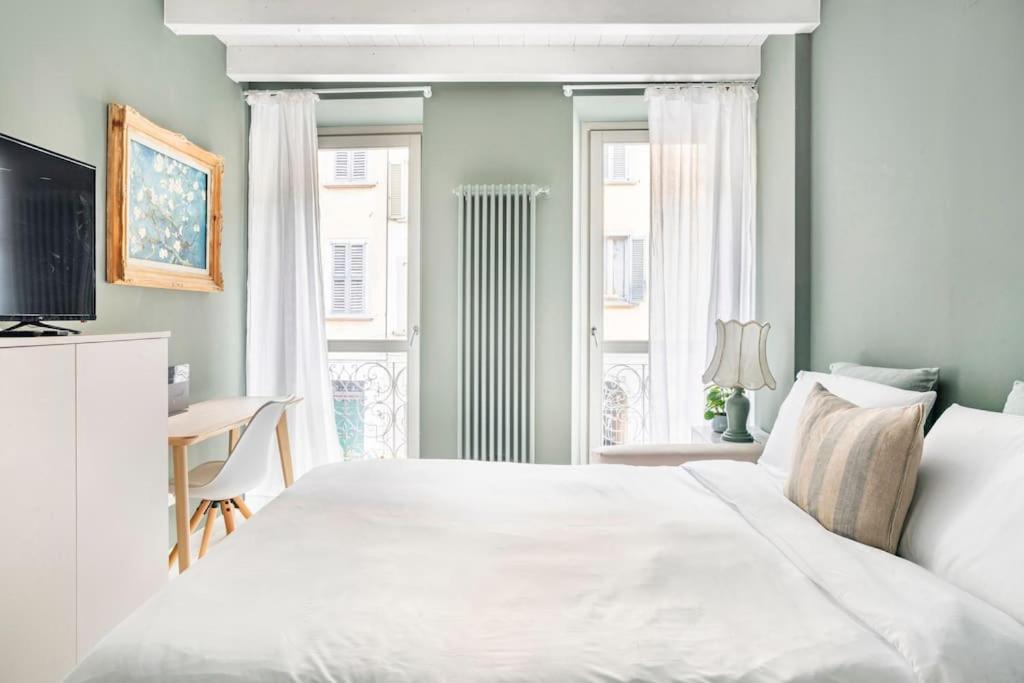 Un dormitorio con una gran cama blanca y una ventana en Bergamo Center [SUITE MIA] - Modern & Green + WiFi, en Bérgamo