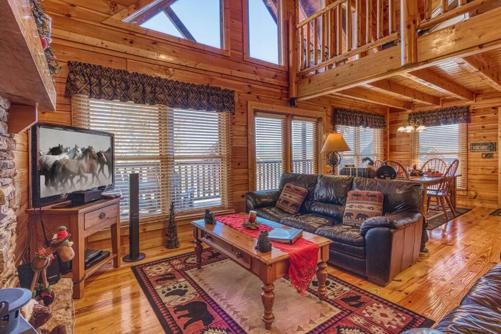 ein Wohnzimmer mit einer Couch und einem Tisch in der Unterkunft Solid Ground Lodge with Yard! in Pigeon Forge