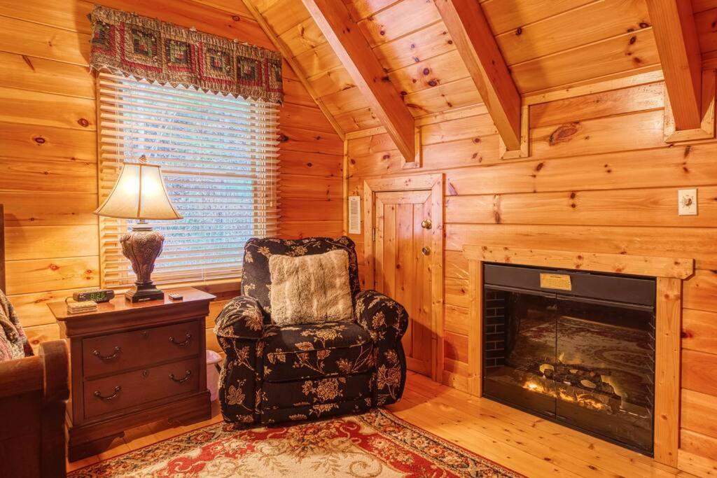 ein Wohnzimmer mit einem Stuhl und einem Kamin in der Unterkunft Solid Ground Lodge with Yard! in Pigeon Forge