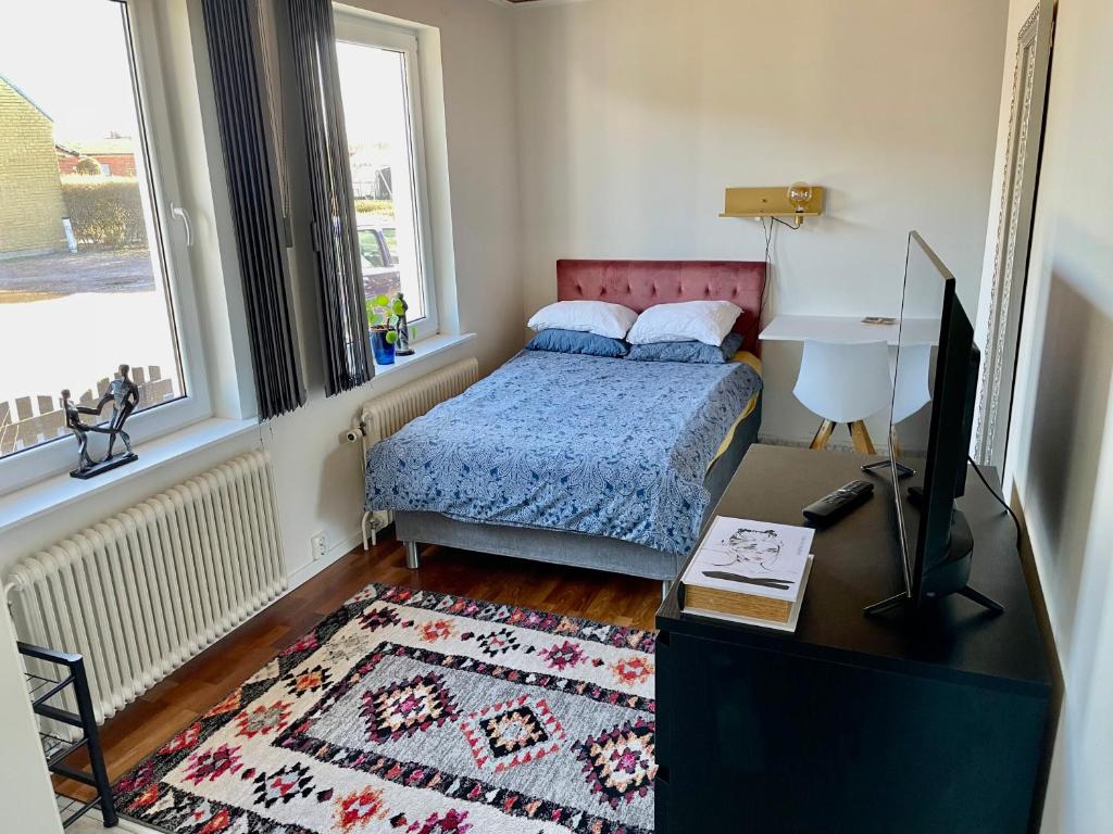 a bedroom with a bed and a desk with a tv at Studio 3 in Landskrona