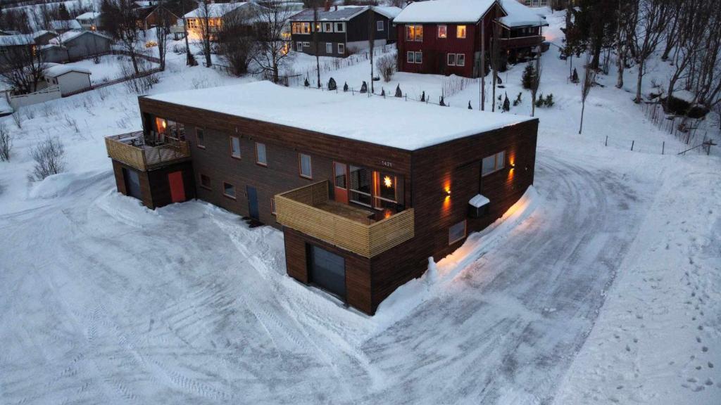 a house in the snow with lights on at Tromsø stunning Luxury apart A in Larseng