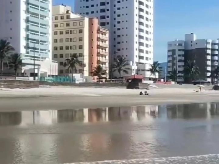 een uitzicht op een strand met gebouwen op de achtergrond bij Apartamento Pé Na Areia in Mongaguá