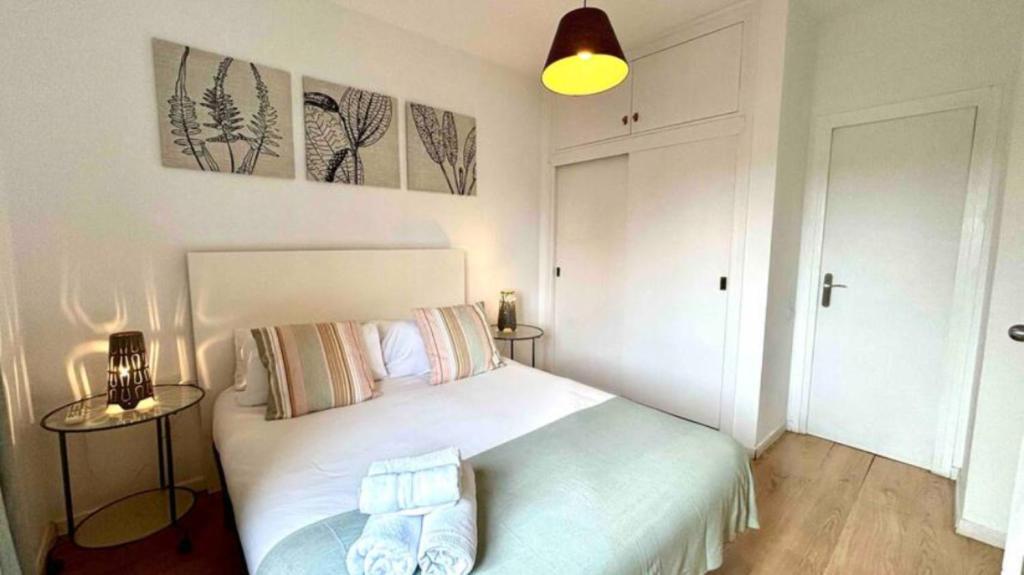 a bedroom with a white bed and two pictures on the wall at SANTS STATION PENTHOUSE in Barcelona