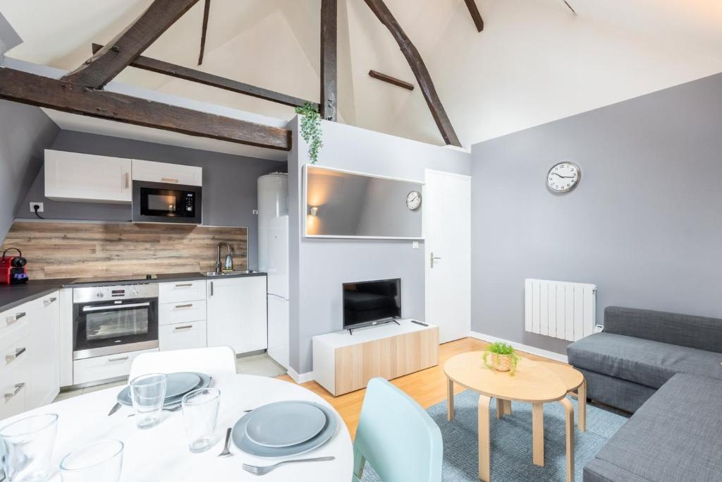 une cuisine et un salon avec une table et un canapé dans l'établissement Lille proche Wazemmes/Jb Lebas - 2 bed apartment, à Lille