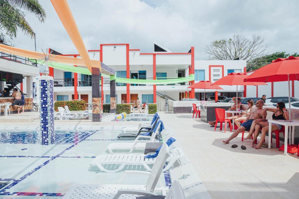 uma piscina com pessoas sentadas em mesas e guarda-sóis em Bora Bora Adults only em Melgar