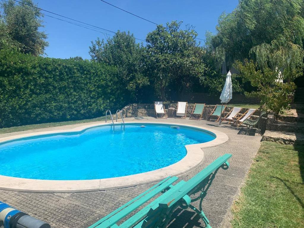 a swimming pool with chairs and a bench next to it at Pool Sea & Country side Villa in Aldeia de São Pedro