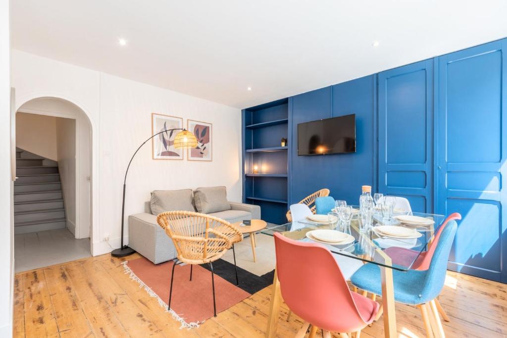 een eetkamer met een tafel en stoelen en een bank bij Bright 3-bedroom 2-bathroom flat in Lille