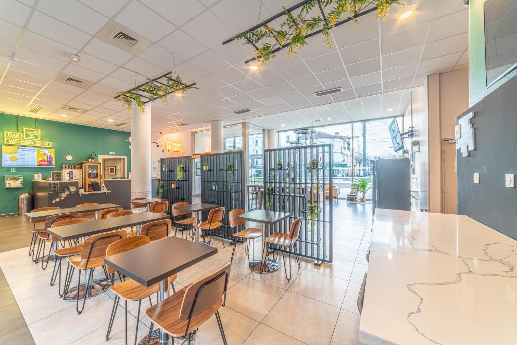 a restaurant with tables and chairs in a cafeteria at Break & Home Paris Italie Porte de Choisy in Ivry-sur-Seine
