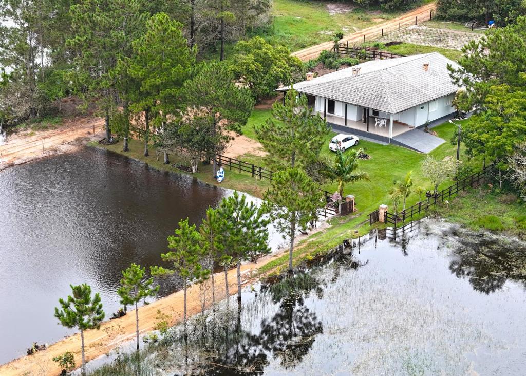 een luchtzicht op een huis naast een meer bij Ampla casa de sítio com lagoa. in Jaguaruna