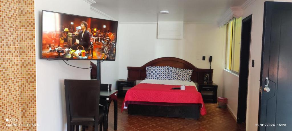 - une chambre avec un lit et une peinture murale dans l'établissement HOTEL EL PARAISO, à Bogotá