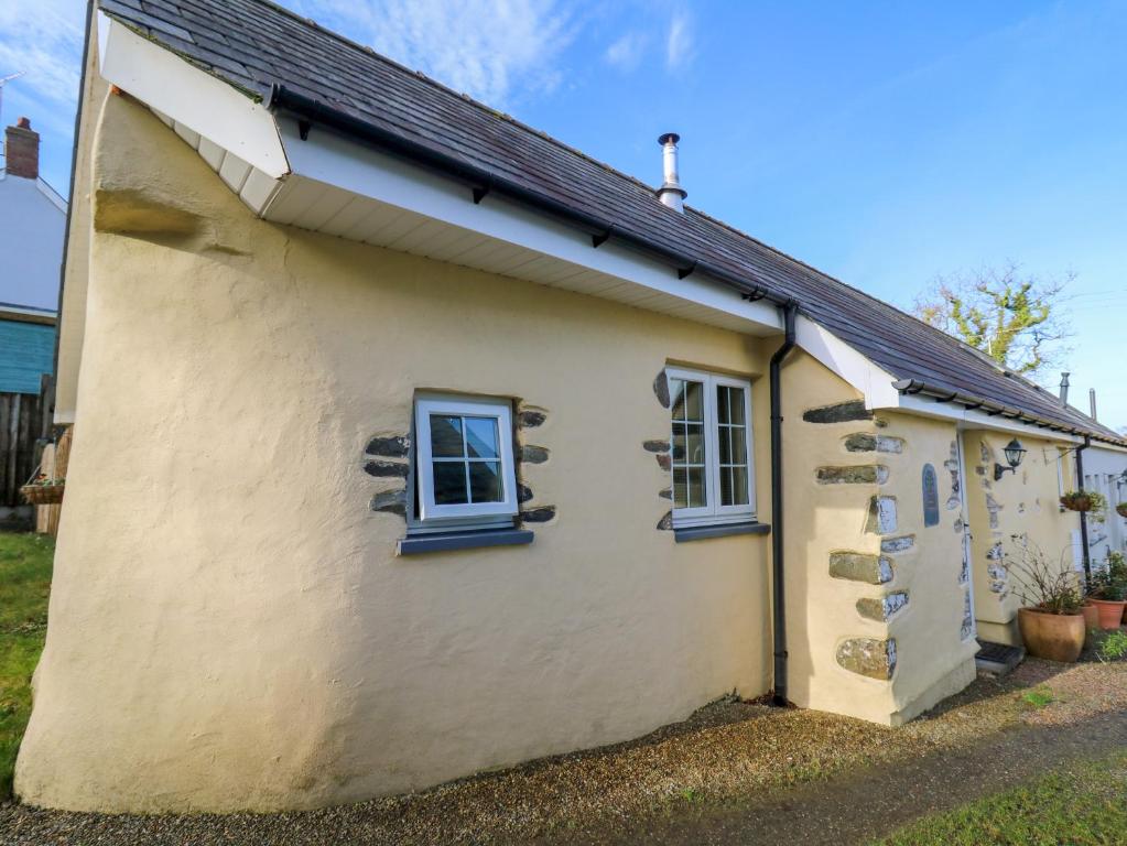 ein kleines weißes Cottage mit einem Gamer-Dach in der Unterkunft Carew in Llandysul