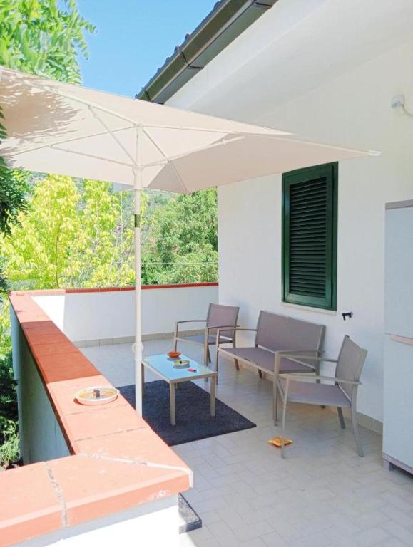 a patio with an umbrella and chairs and a table at CILENTO CASE&VACANZE - Villa Leyland in Laureana Cilento