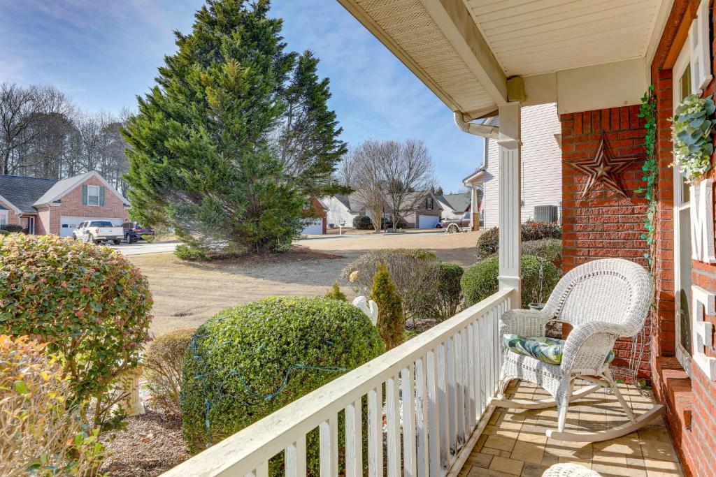 a porch with two chairs and a fence at Cozy Buford Home with Piano about Mins to Lake Lanier! in Buford