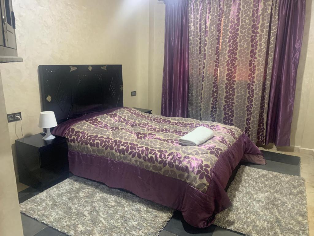 1 dormitorio con 1 cama con edredón morado en L'hivernage Marrakech, en Marrakech