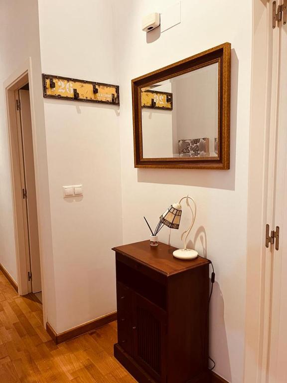 Habitación con espejo y mesa con lámpara. en Bonito Piso con 2 habitaciones, en Porto do Son