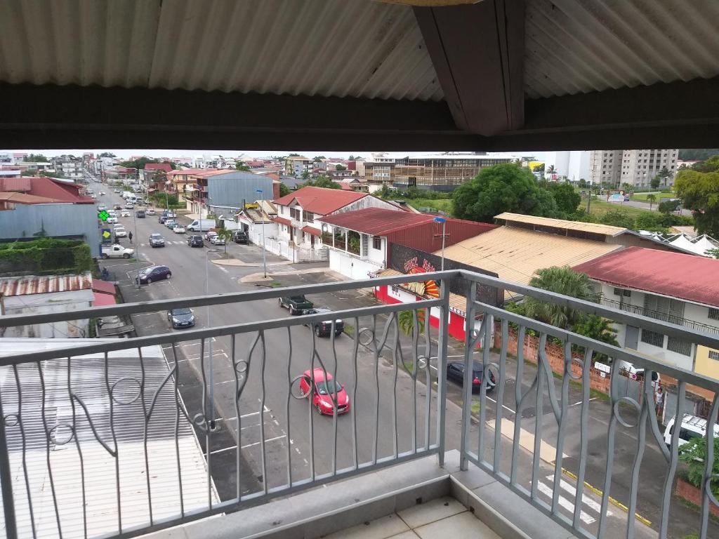 a balcony with a view of a city street at NANA A33 Appartement 2 Chambres Climatisées cuisine équipée Netflix in Cayenne