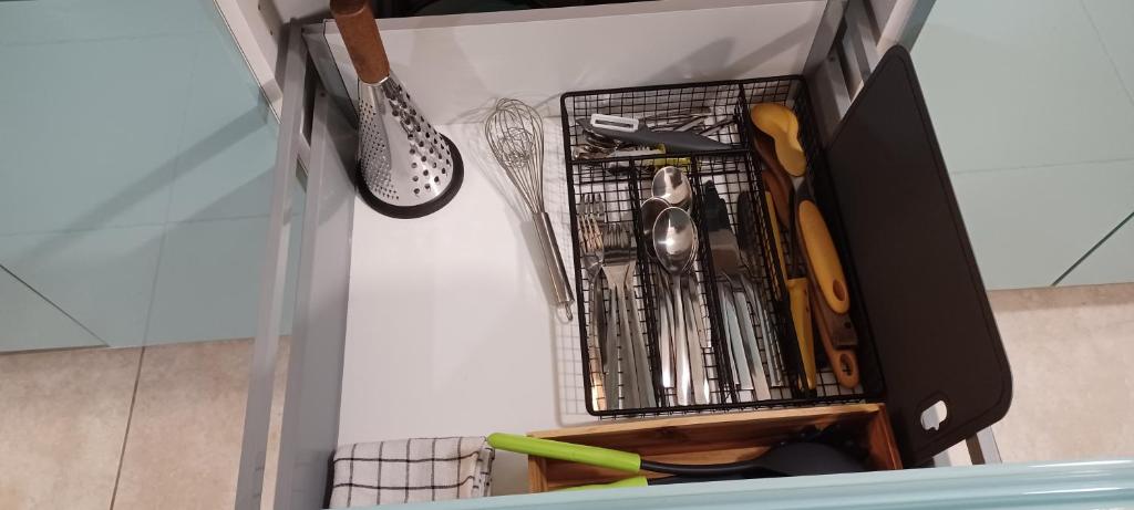 a drawer full of utensils in a cabinet at NANA A33 Appartement 2 Chambres Climatisées cuisine équipée Netflix in Cayenne
