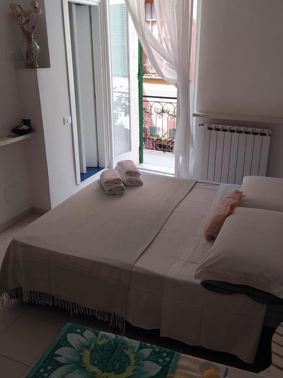 a large bed in a room with a window at Chez Tamara with private parking and air conditioned in Monterosso al Mare
