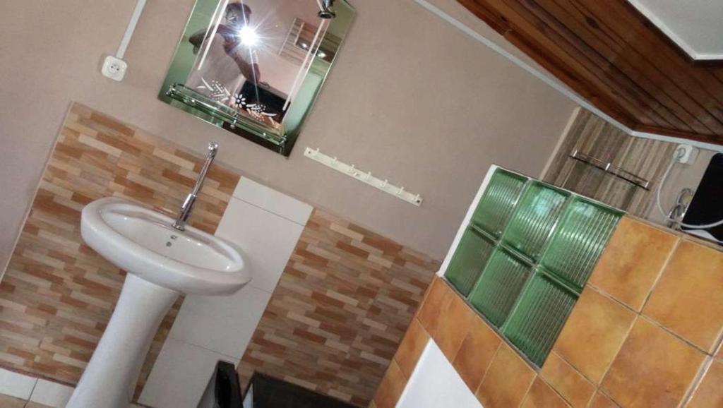 a person taking a picture of a bathroom with a sink at Appartement LiHeRo in Antananarivo