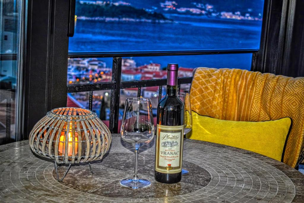 - une bouteille de vin assise sur une table avec un verre dans l'établissement Terminal Vidikovac, à Budva