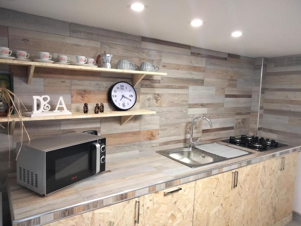 una cucina con forno a microonde e orologio a muro di D&A a Boscoreale